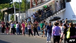 Migrantes esperan afuera de la oficina regional del Instituto Nacional de Migración para esperar su salvoconducto para transitar por territorio mexicano en su camino a Estados Unidos, en Tapachula, estado de Chiapas, México, el 13 de enero de 2025. ALFREDO ESTRELLA / AFP