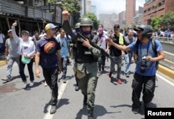 Un miembro de la Guardia Nacional Bolivariana se une a los manifestantes de la oposición durante las protestas en Caracas.