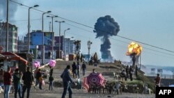 Los palestinos se reúnen en la playa de la ciudad de Gaza en forma de humo y bombardeo después de los ataques aéreos de Israel en respuesta a los cohetes lanzados por militantes palestinos el 4 de mayo de 2019.