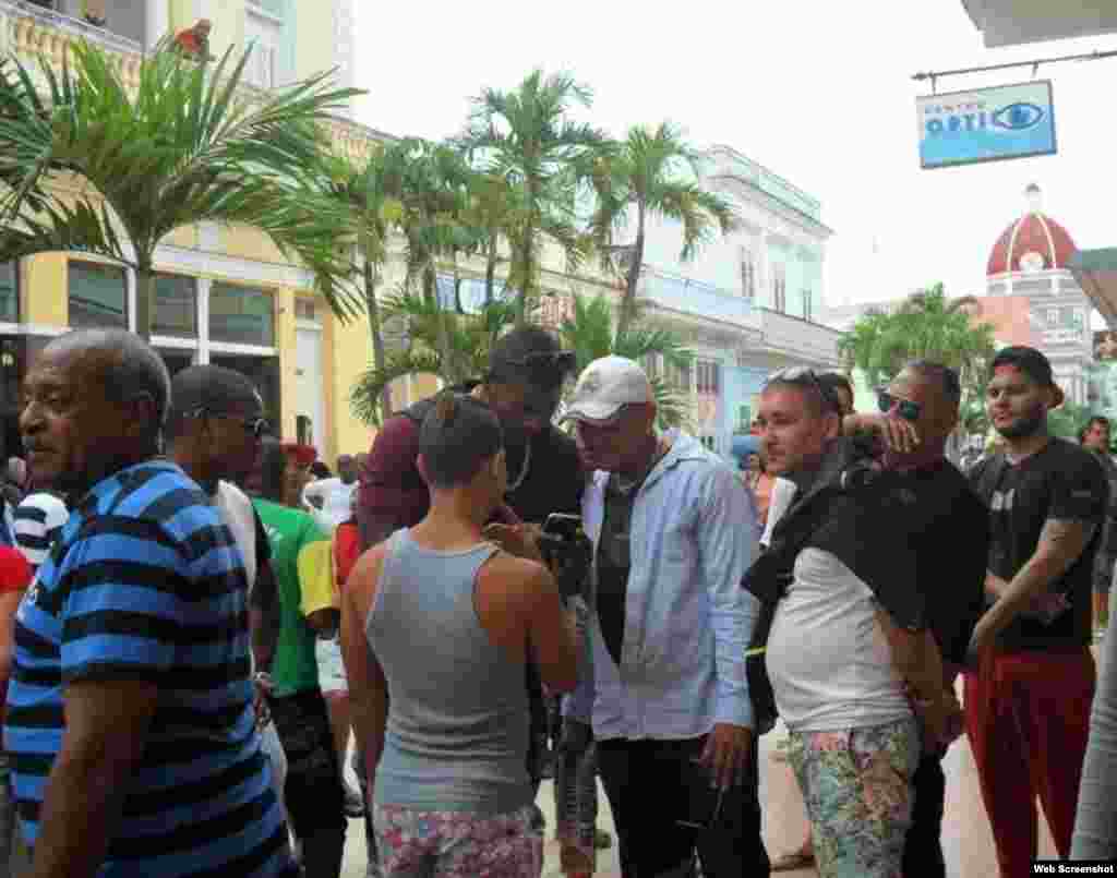 Yasiel Puig anota un número telefónico en su celular durante su recorrido por el Boulevard de Cienfuegos.